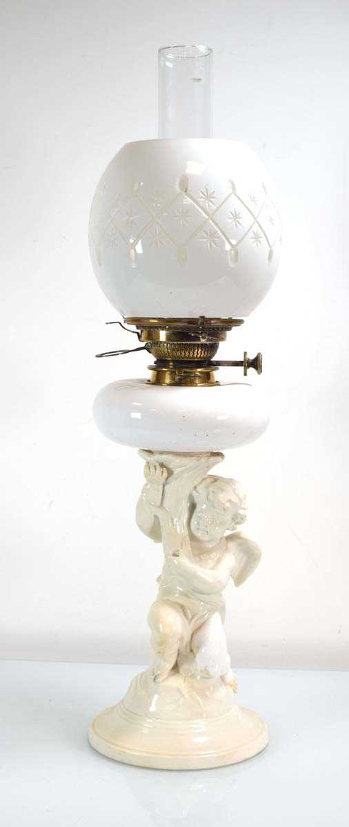 A Copelands China oil lamp with a figural column, white opaline reservoir and matching shade