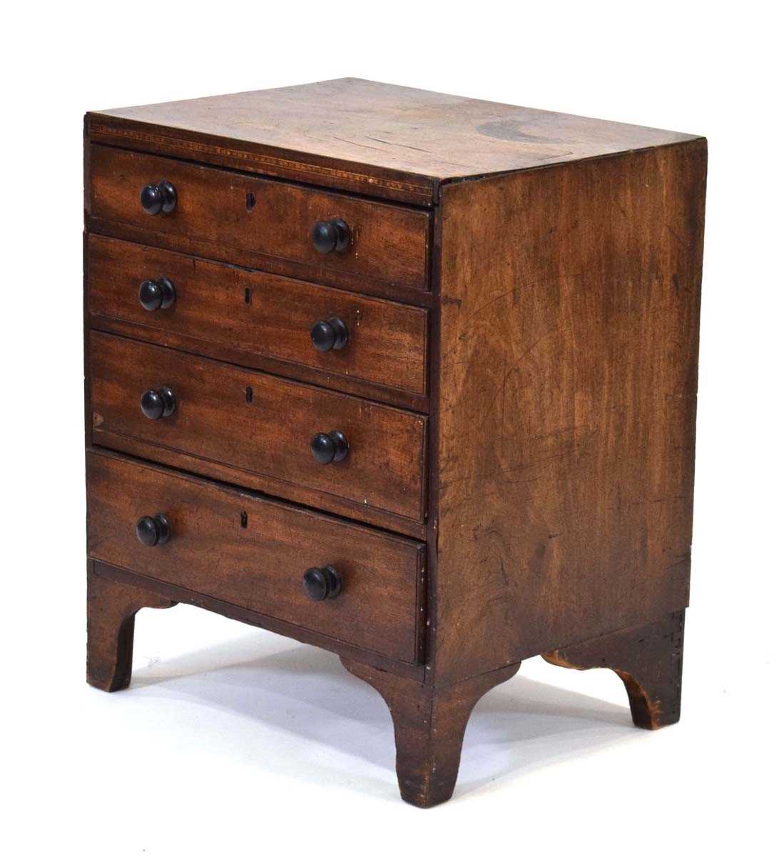 A Georgian mahogany chest of four long graduated drawers, marquetry work to the frieze, on bracket