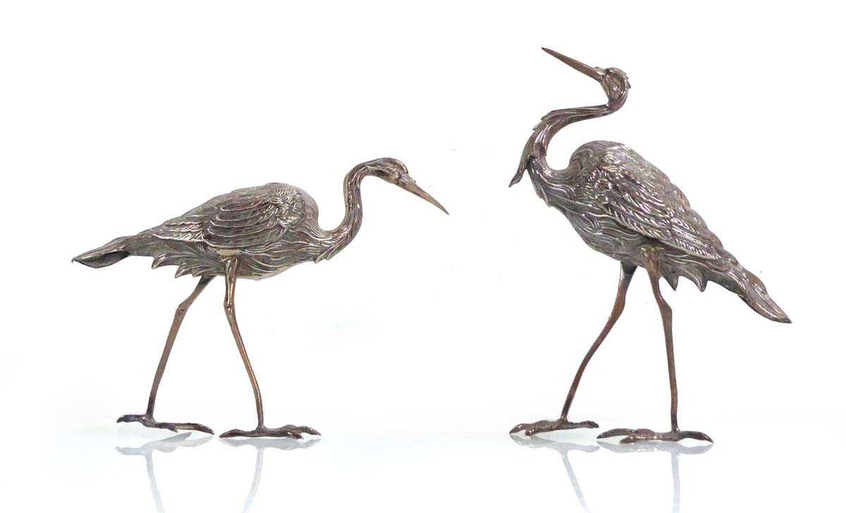 A pair of metalware figures, each modelled as a standing heron, max h. 16 cm, 4 ozs (2) Slightly