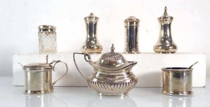 A group of silver comprising an oval mustard, three salts, two peppers and a dressing table