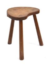 A Robert 'Mouseman' Thompson carved oak stool with a shaped seat, three chamfered legs and the mouse