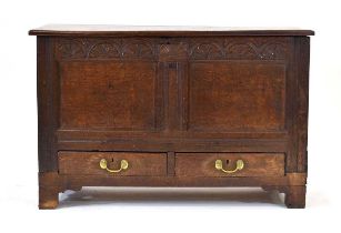 An 18th century mule chest, the surface over a carved frieze, two-panelled front and two drawers