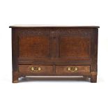 An 18th century mule chest, the surface over a carved frieze, two-panelled front and two drawers