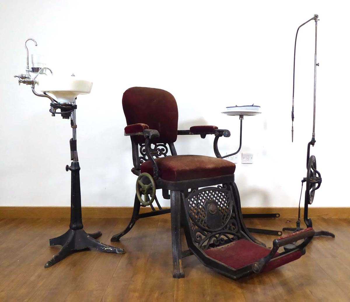 A 19th century cast metal reclining dentists' chair, a WDM Co. pedal operated drill and a rinsing