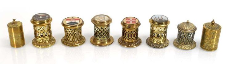 A group of eight brass match holders, some with enamel work, including 'Prince Albert's Safety Box',