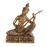 A South East Asian gilt metal figure modelled as the Thai Prince Phra Aphai Mani playing the