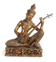 A South East Asian gilt metal figure modelled as the Thai Prince Phra Aphai Mani playing the