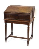 An oak clerk's desk, the sloped surface enclosing six drawers, on a later oak stand, 68 x 52 x 91