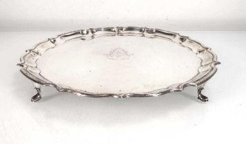 An early 20th century silver salver of circular form on four paw feet, Stewart Dawson Ltd., London