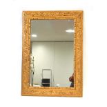 A giltwood wall mirror, the rectangular plate within a foliate frame, 107 x 76 cm Size of mirror