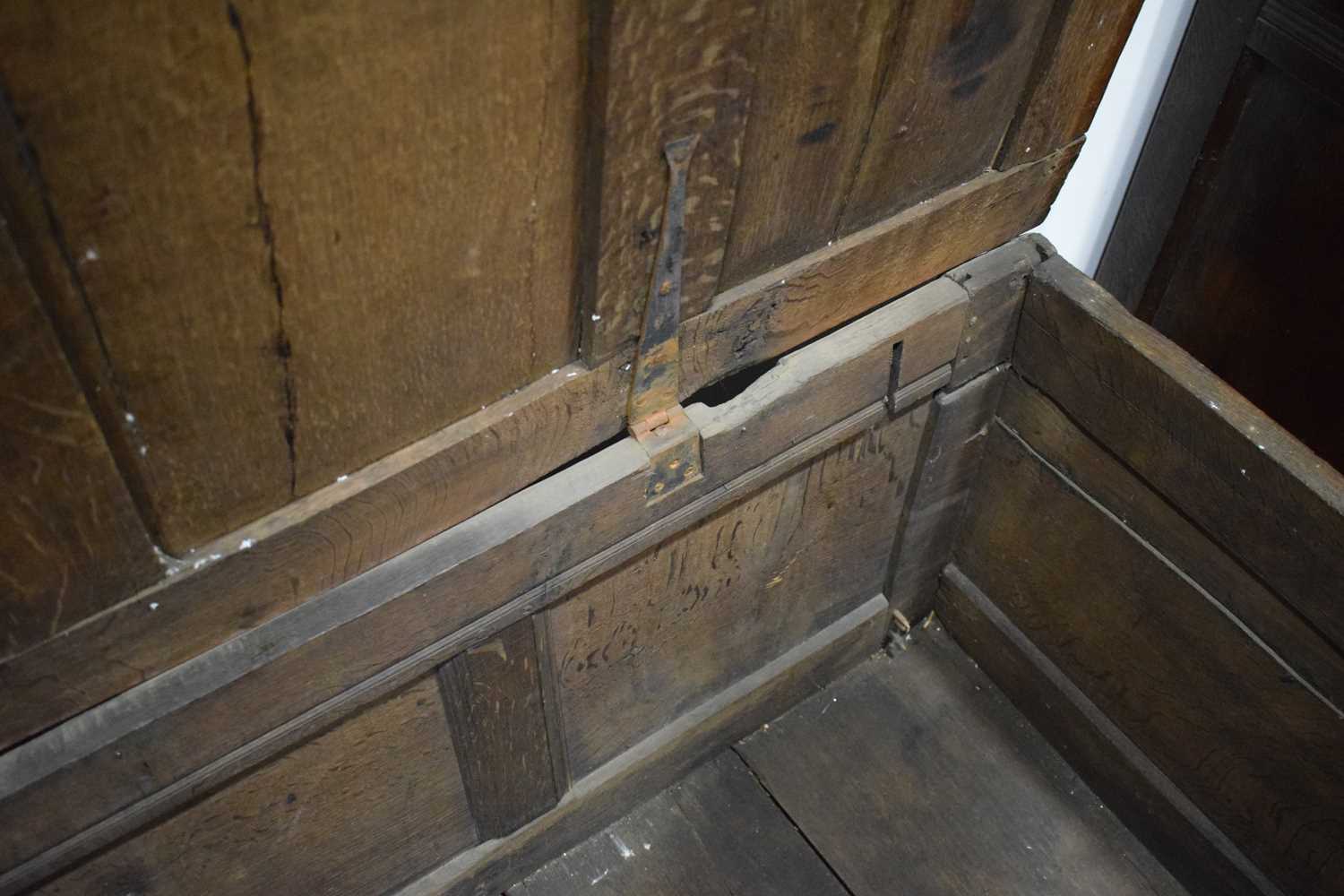 An 18th century oak coffer of long proportions, the four-panelled surface over two later carved - Image 12 of 16