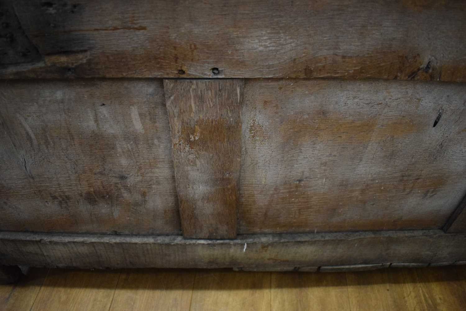An 18th century oak coffer of long proportions, the four-panelled surface over two later carved - Image 9 of 16