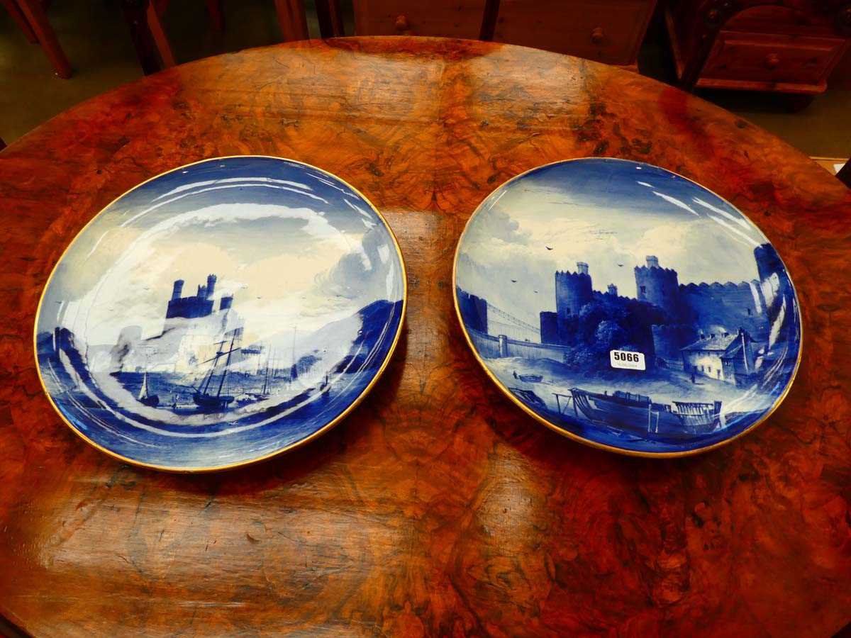 A pair of blue and white Copeland chargers decorated with views of Carnarvon and Conwy Castle, d.