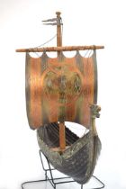 A patinated copper sculpture modelled as a Viking longship with billowing sail, 44 x 10 x 40 cm,