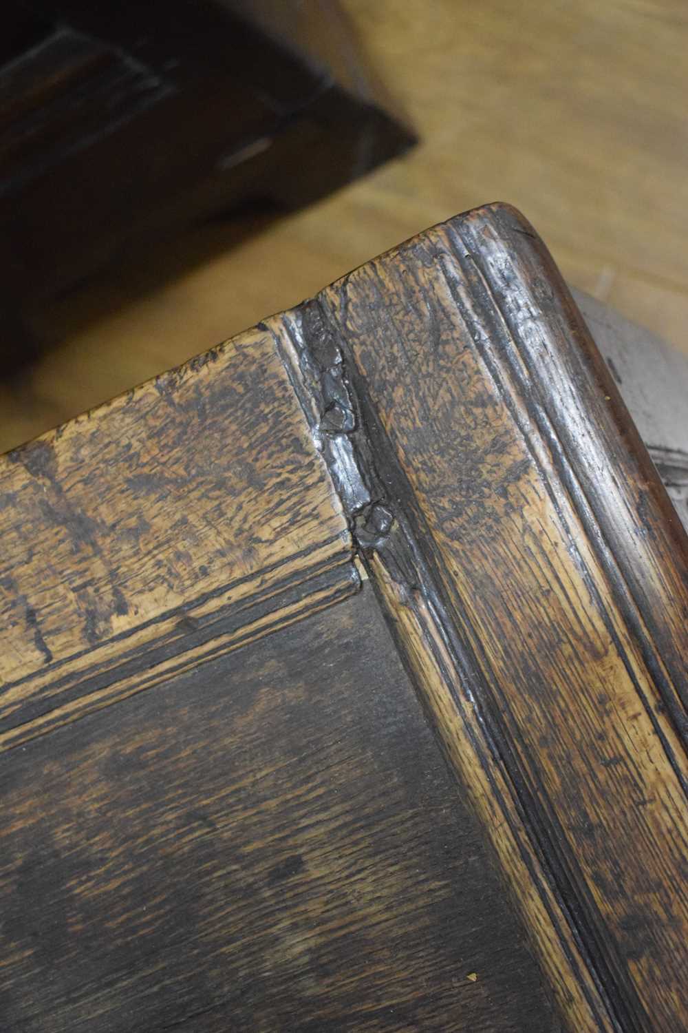 An 18th century oak coffer of long proportions, the four-panelled surface over two later carved - Image 4 of 16