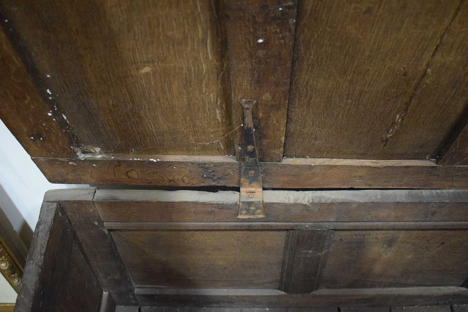 An 18th century oak coffer of long proportions, the four-panelled surface over two later carved - Image 14 of 16