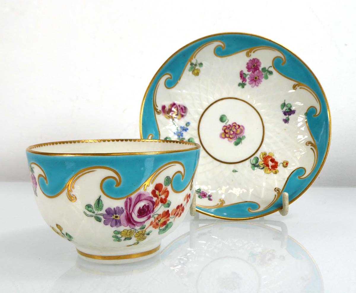 A Chelsea tea bowl and saucer dish decorated with floral sprays on a turquoise ground, saucer d.