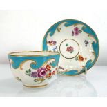 A Chelsea tea bowl and saucer dish decorated with floral sprays on a turquoise ground, saucer d.