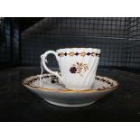 A 19th century tea cup and saucer dish, gilt decorated with a band of stylised blue flowers,