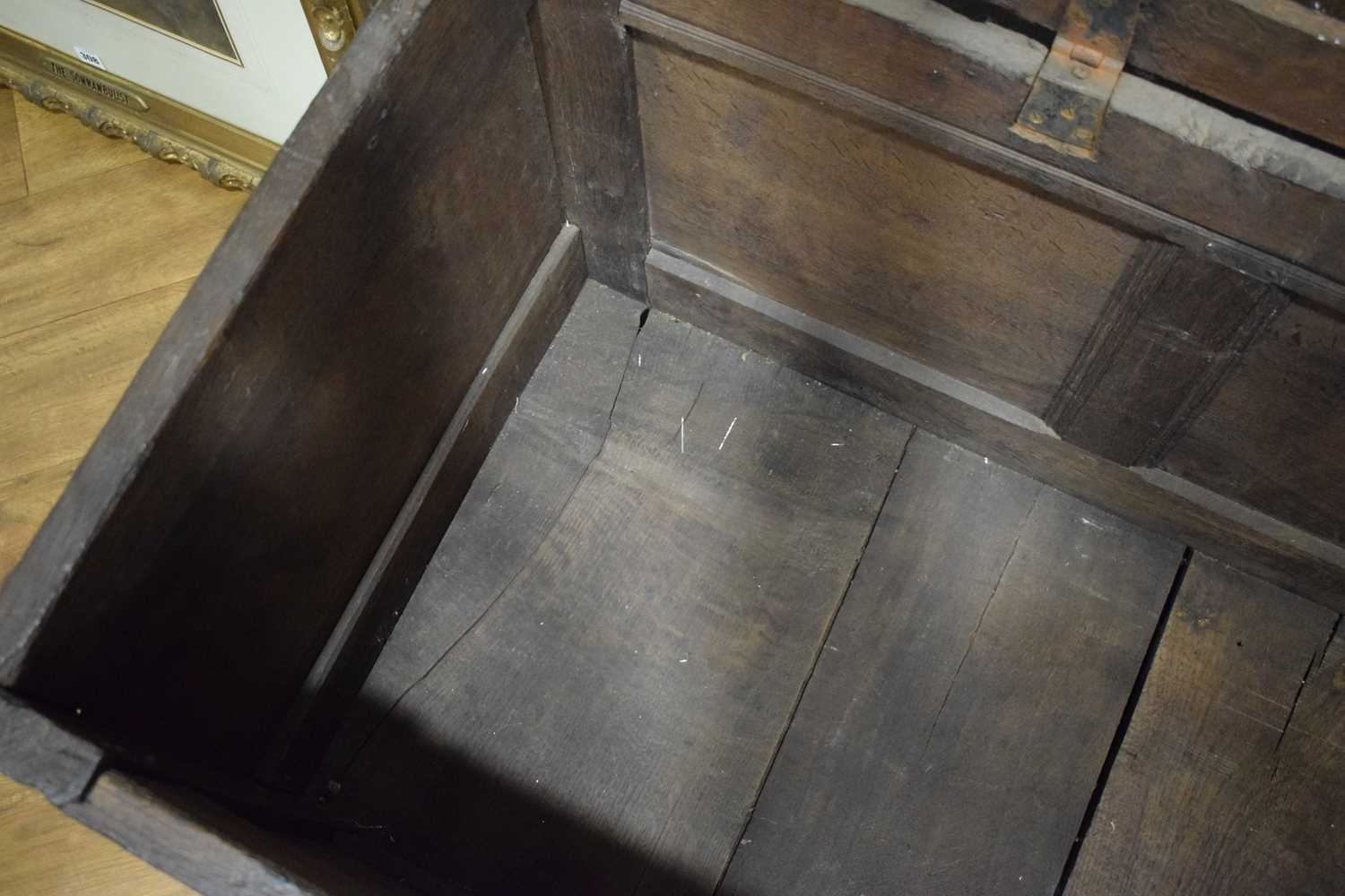 An 18th century oak coffer of long proportions, the four-panelled surface over two later carved - Image 13 of 16