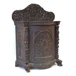 A 19th century Anglo-Indian (?)padouk side cabinet, the intricately carved back over a bow-front and