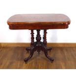 A Victorian figured walnut and marquetry games table on four turned columns and splayed legs with