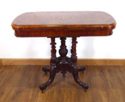 A Victorian figured walnut and marquetry games table on four turned columns and splayed legs with