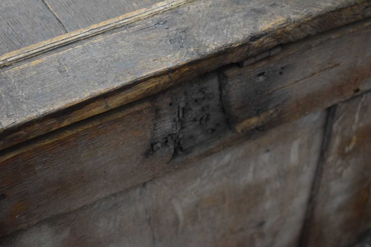 An 18th century oak coffer of long proportions, the four-panelled surface over two later carved - Image 6 of 16