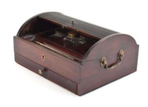 A Victorian mahogany desk tidy, the tambour top enclosing spaces for three inkwells (only one