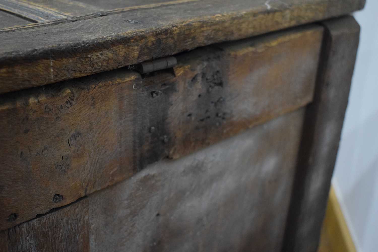 An 18th century oak coffer of long proportions, the four-panelled surface over two later carved - Image 7 of 16