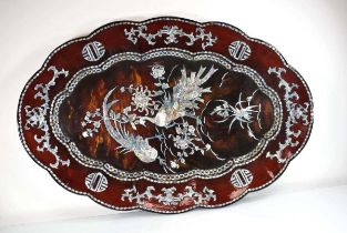 A Japanese black lacquered tray decorated with mother-of-pearl motifs and birds, on a faux