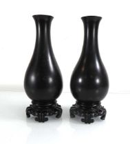 A pair of Japanese lacquered baluster vases with floral decoration, attached to hardwood stands,