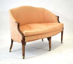 A Georgian camel back sofa, the mahogany frame with peach floral upholstery, on tapering legs with