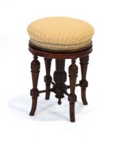 A Victorian mahogany and upholstered adjustable stool on turned legs joined to a central column,