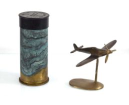 A brass desk piece modelled as a spitfire together with a 1950's British engine starter cartridge (