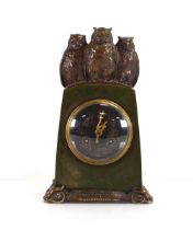 An Arts & Crafts clock, the green patinated case surmounted by three bronze owls, the circular
