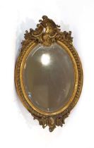 A late 19th century French wall mirror, the oval bevelled plate within a giltwood frame, 90 x 53 cm