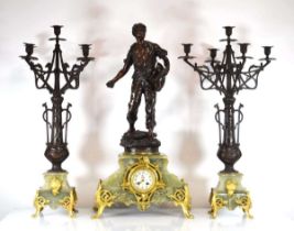 A 19th century French clock and garnitures, the green marble body surmounted by a spelter figure