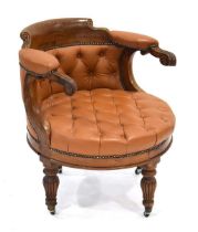 An early 20th century oak library chair, the carved frame with brown button upholstery on reeded
