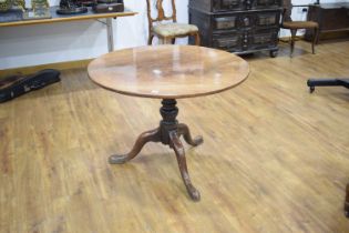 A George III mahogany tilt-top supper table, the circular surface on a turned column and splayed