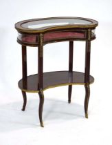 An early 20th century bijouterie table of kidney form with brass mounts, a second tier and