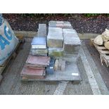 Pallet containing various pieces of building material, including blocks, edging, tiles, glass
