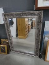 Rectangular bevelled mirror in ornate floral frame Approx. dimensions: 114cm x 82cm