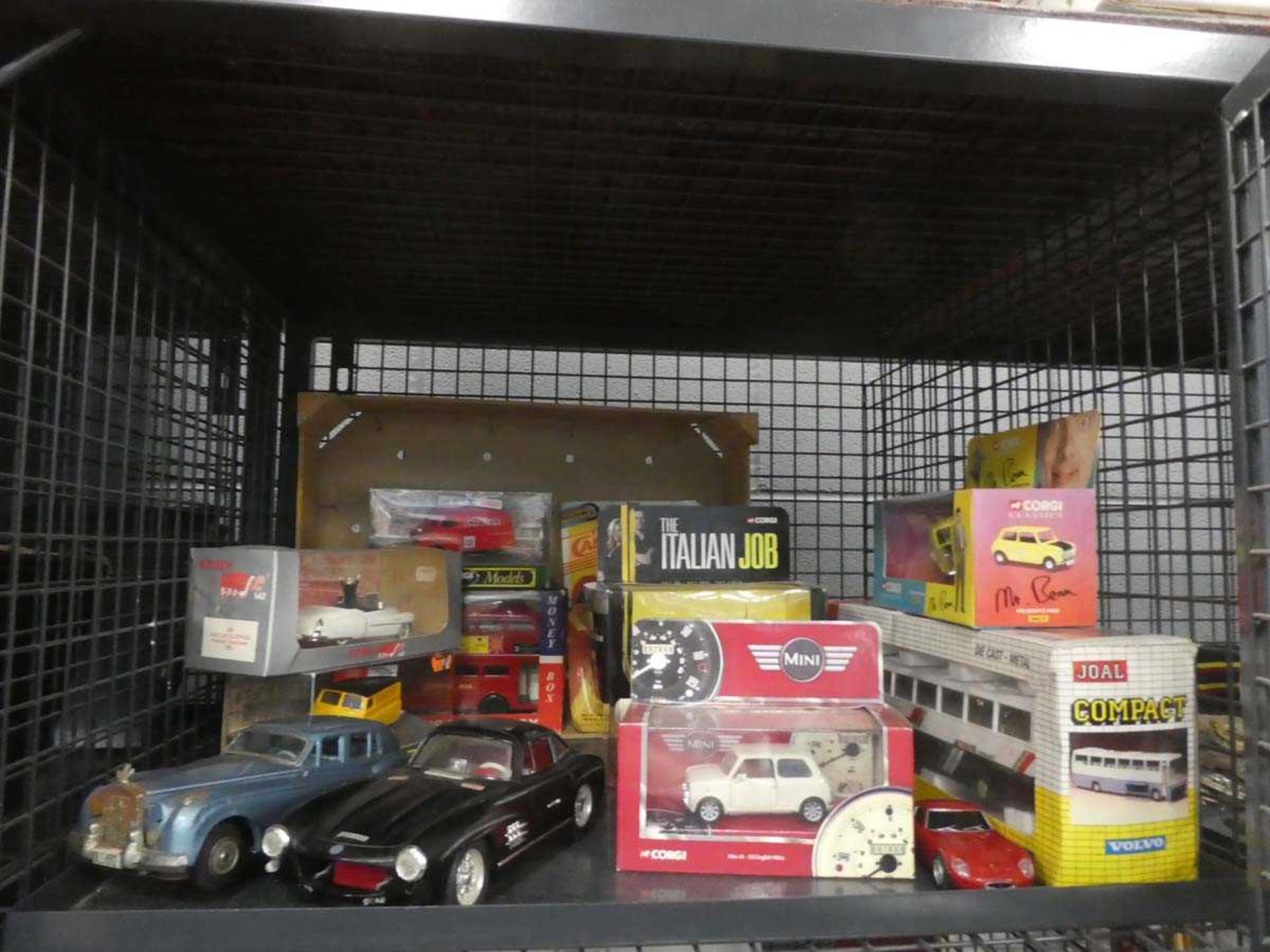 Cage containing various boxed and loose die cast vehicles