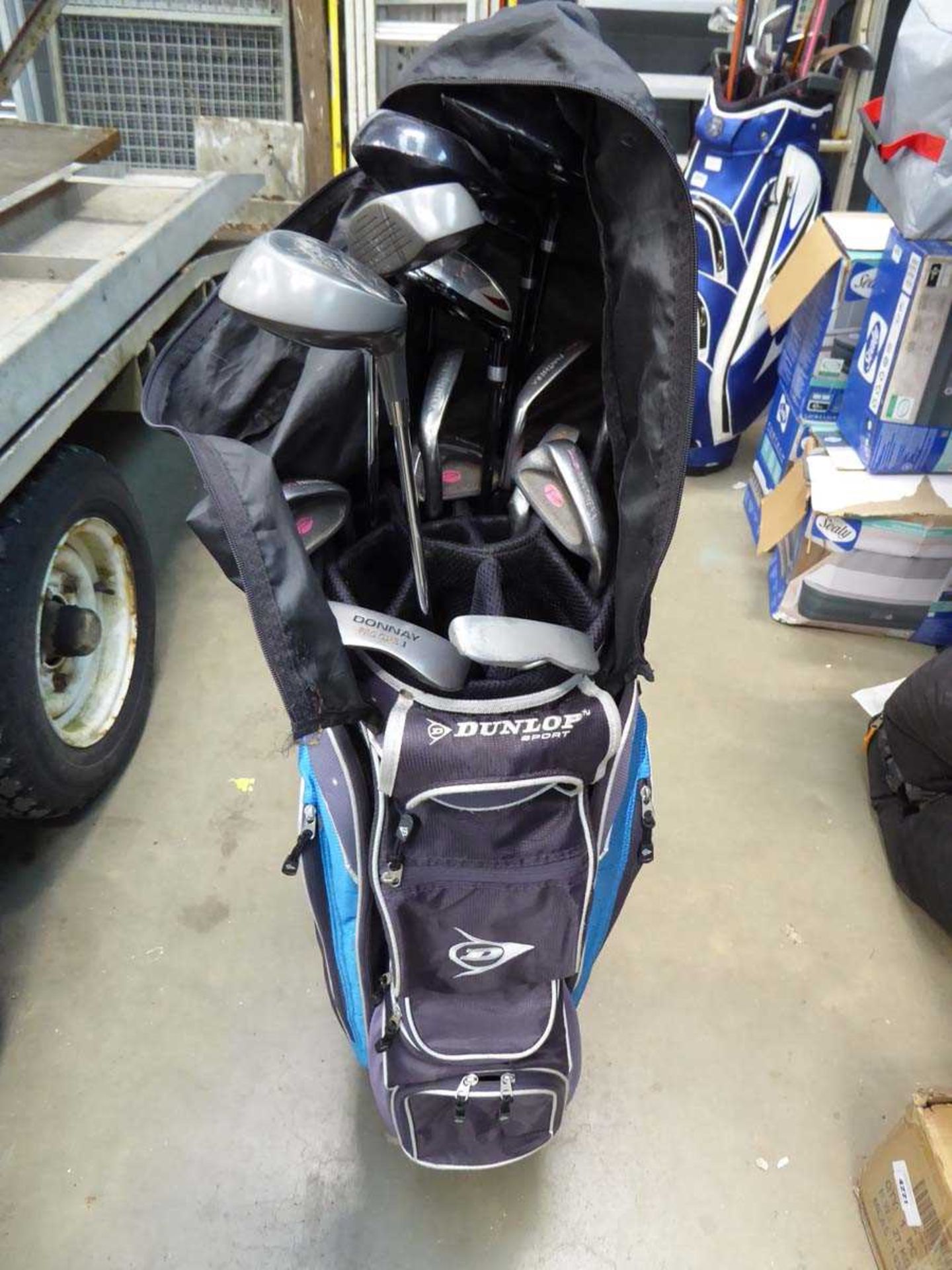 Blue and black Dunlop golf bag with assortment of clubs