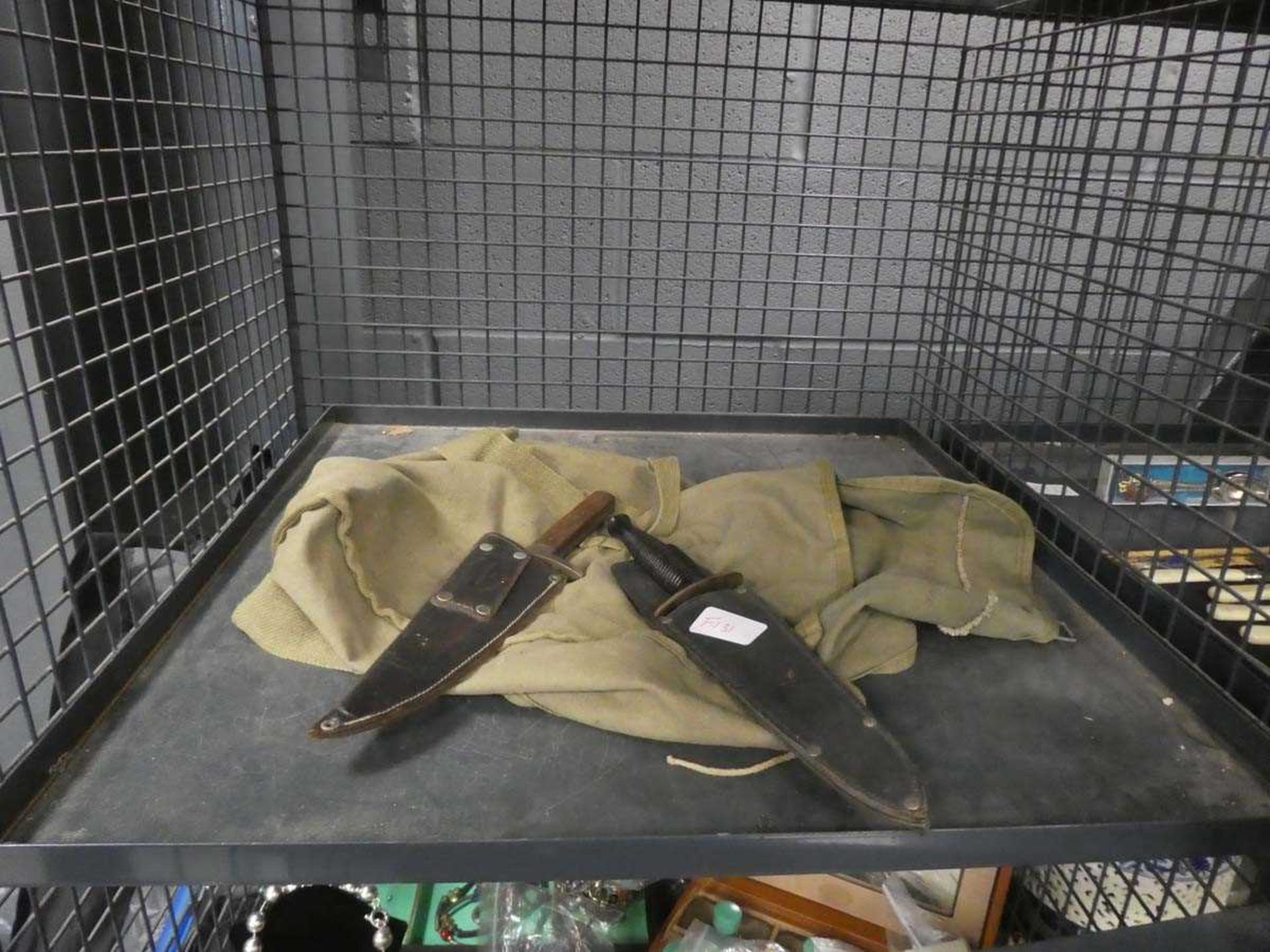 Cage containing canvas bag and 2 Commando knives