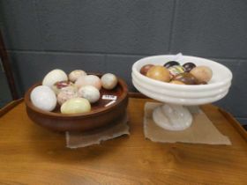 Two onyx and wooden fruit bowls with quantity of artificial stone and wooden eggs