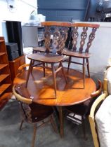 Old brown Ercol dining suite comprising a circular drop leaf table and 6 matching dining chairs
