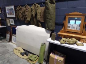 Military green canvas duffle bag containing a variety of uniform, including battledress, trousers,
