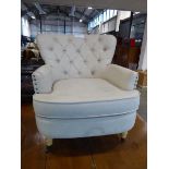 Modern off white button backed upholstered and brass studded easy chair